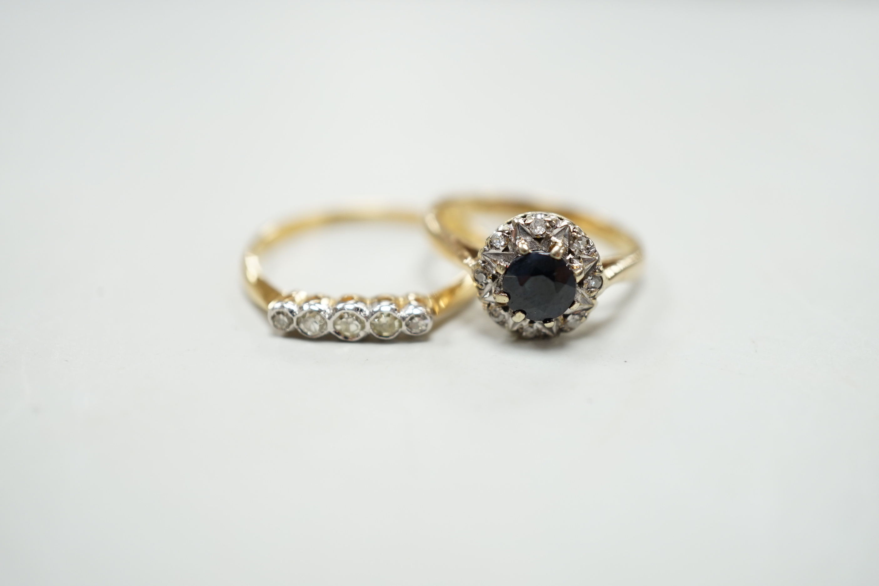 An 18ct and five stone diamond chip set half hoop ring and a modern 9ct gold, sapphire and diamond cluster ring.